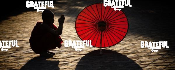 Monk with parasol praying in Bagan, Burma