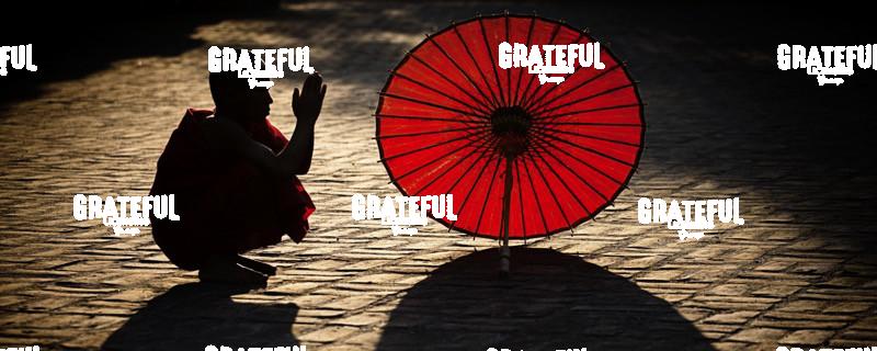 Monk with parasol praying in Bagan, Burma
