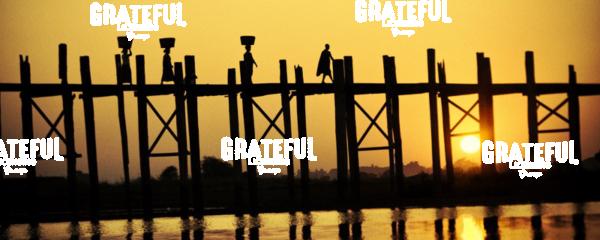 People walking across the UBein bridge at sunset in Mandalay, Burma
