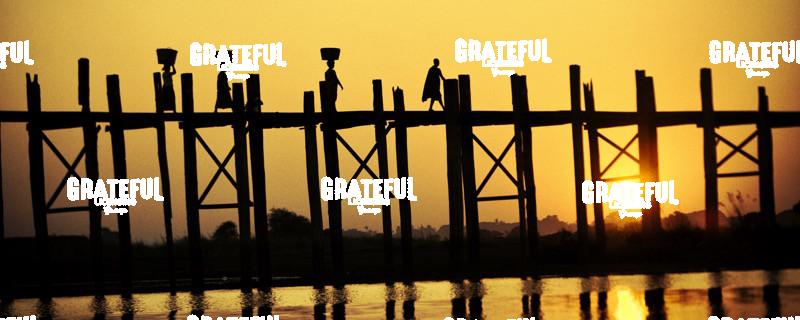 People walking across the UBein bridge at sunset in Mandalay, Burma