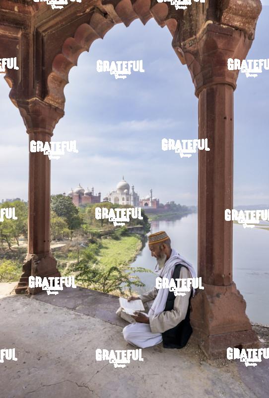 Holy Man in prayer and reading by the Taj Mahal
