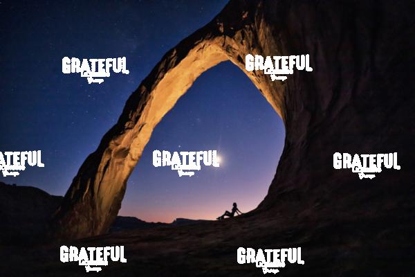 Silhouette of a woman under Corona Arch in Moab, Utah